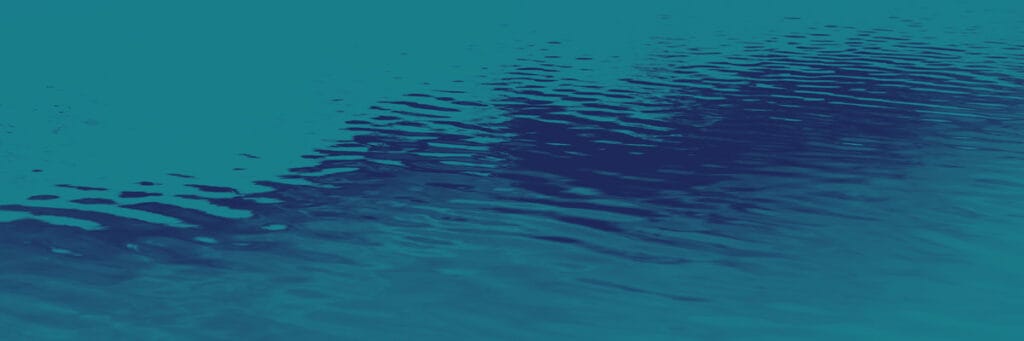 A close-up view of calm blue water with gentle ripples and reflections on the surface.