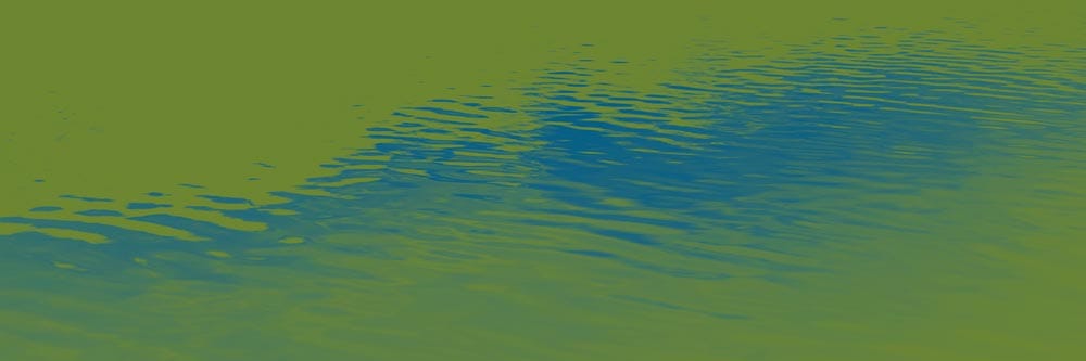 Rippling water with blue and green reflections on the surface.